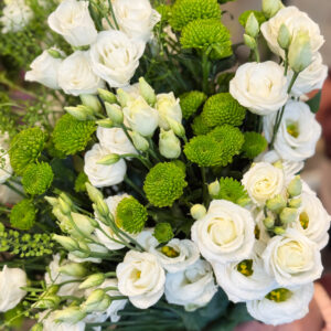 Κεντρικό ρόλο στη σύνθεση κατέχουν οι λυσίανθοι, λουλούδια που ξεχωρίζουν για τη λεπτότητα και την αέρινη υφή τους. Με τα απαλά λευκά πέταλα και τα πράσινα μπουμπούκια τους, αποπνέουν ρομαντισμό, αγνότητα και διακριτική φινέτσα.