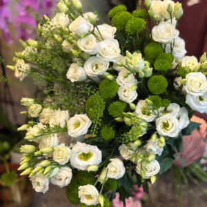 Κεντρικό ρόλο στη σύνθεση κατέχουν οι λυσίανθοι, λουλούδια που ξεχωρίζουν για τη λεπτότητα και την αέρινη υφή τους. Με τα απαλά λευκά πέταλα και τα πράσινα μπουμπούκια τους, αποπνέουν ρομαντισμό, αγνότητα και διακριτική φινέτσα.