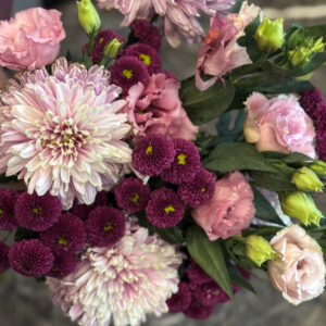 Οι λυσίανθοι στις απαλές ροζ αποχρώσεις τους λειτουργούν σαν «γέφυρα» ανάμεσα στα μωβ και τα λιλά χρυσάνθεμα, ενοποιώντας τη χρωματική παλέτα με φυσική χάρη. Είναι λουλούδια με διάρκεια, που διατηρούν τη φρεσκάδα τους για πολλές ημέρες, κάτι που κάνει την ανθοδέσμη ιδανική επιλογή τόσο για δώρο όσο και για διακόσμηση.