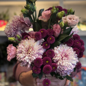 Στην ίδια σύνθεση, οι λυσιάνθοι προσθέτουν ένα πιο ρομαντικό και αέρινο στοιχείο. Πρόκειται για άνθη με λεπτά, μεταξένια πέταλα και πράσινα μπουμπούκια που σταδιακά ανοίγουν, συμβολίζοντας την αναγέννηση και τη φρεσκάδα.